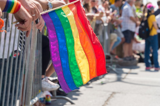 Gay rainbow flag at Montreal Gay Pride Parade 2017 with blurred spectators in the background
