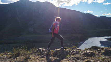 Obraz premium Hiker with backpack hiking on top of a mountain with sun flares. Young woman healthy active lifestyle. Adventure in Nature.