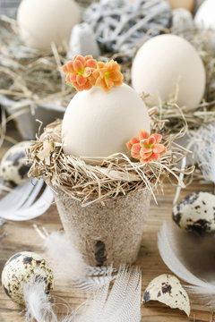 Simple easter decoration with egg, hay wreath and Kalanchoe blossfeldiana flowers.