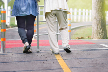 Elderly woman exercise walking in road with daughter with daughter