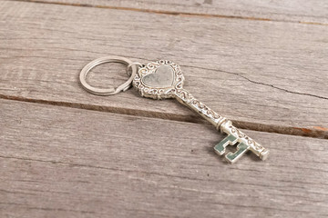 Vintage key. Vintage key with heart shape isolated on the wooden background