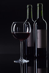 Bottles and glass of red wine .