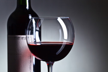 Bottle and glass of red wine .