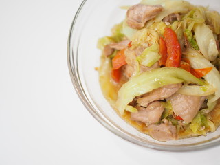 Thai local homemade stir fried chicken with cabbage and tomato in glass bowl, white background
