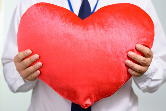 Businessman giving a red heart to a customer,Positive concept.