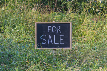 signboard "for sale" on a meadow/real estate sign