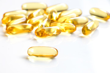 Yellow color soft gelatin capsule on white background (Concept of medicine, drug, nutrition supplement)