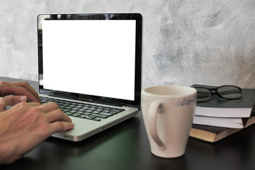 Fototapeta premium Close up of male hands using laptop with white screen monitor on the desk.