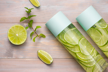 Fototapeta na wymiar Detox Infused Water with Lime and Mint in Sports Bottle, with slices of lime.