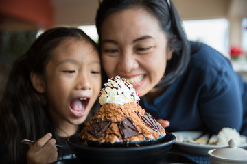 Mother and daughter enjoy eating Korean style icecream or bingsu with chocolate flavour
