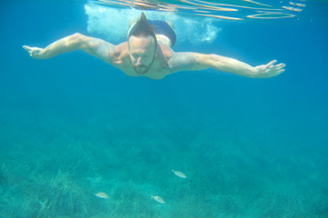 Fototapeta na wymiar Man swimming underwater
