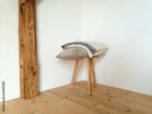 Schemel mit Kissen und Decke im Schlafzimmer eines rustikalen ... Schemel mit Kissen und Decke im Schlafzimmer eines rustikalen ...