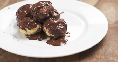 profiteroles with fine dark chocolate on plate