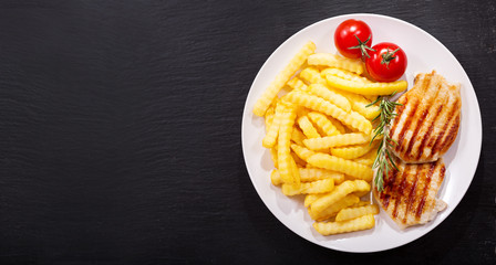 plate of grilled pork chop with french fries