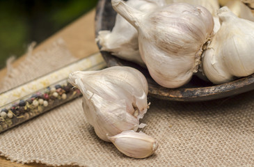 Garlic tubers in rustic wooden bowl on burlap