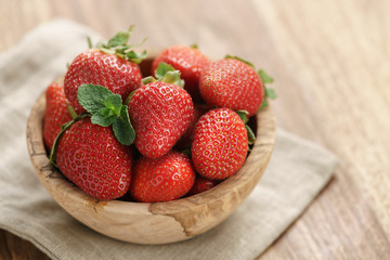 fresh strawberries in bowl on wood table