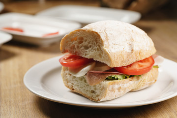 ciabatta sandwich with speck, mozzarella and vegetables