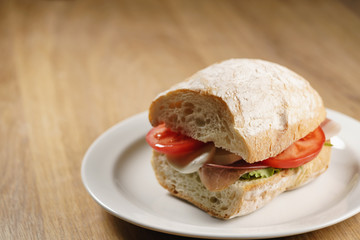 ciabatta sandwich with speck, mozzarella and vegetables