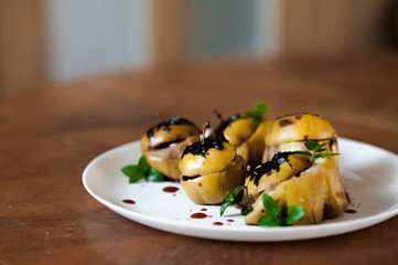 Baked apples with cottage cheese, chocolate, nuts, mint. Apples on a white plate