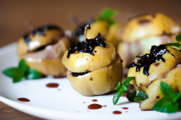 Baked apples with cottage cheese, chocolate, nuts, mint. Apples on a white plate