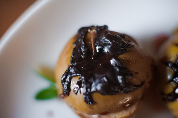 Baked apples with cottage cheese, chocolate, nuts, mint. Apples on a white plate