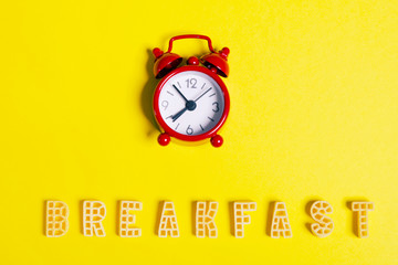 Word: "breakfast" and a red alarm clock on a yellow background
