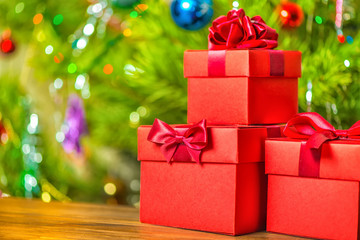 Obraz premium concept Christmas holiday of red gift boxes with bow on wooden background over festive decoration, close up
