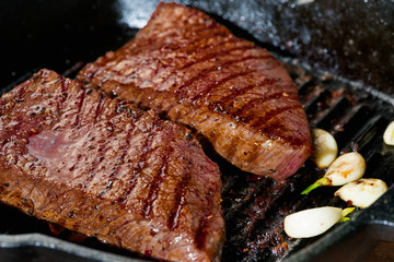 grilled beef with garlic on pan, close up