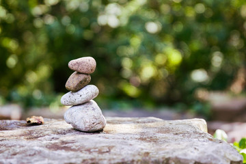 Fototapeta na wymiar A stack of stones balances in a garden