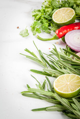 Food cooking background, white marble table. Spices, herbs for dinner - coriander, parsley, basil, rosemary, lime, tomato, salt, pepper, garlic, onion, red chili pepper. Copy space