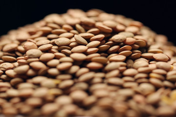 Heap of green lentils isolated on black