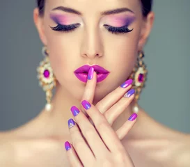 Rolgordijnen Mooi meisje model met mode violet make-up en paarse design manicure op nagels. Sieraden en cosmetica, grote paarse oorbellen © Sofia Zhuravetc
