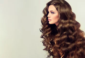 Wall murals Hairdressers Brunette  girl with long  and   shiny wavy hair .  Beautiful  model with curly hairstyle .  