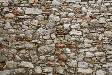 Old stone layered wall of fortress or castle