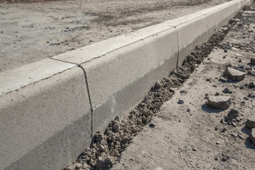 Sidewalk under construction, concrete curb  installation in progress.