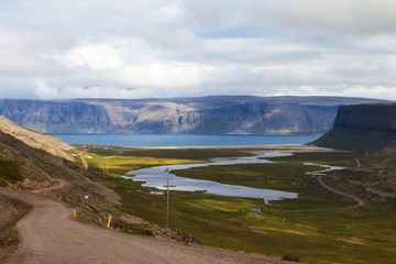 Fototapeta na wymiar Iceland, typical icelandic landscape in summer. Fiord, mountains, bay, roadway.