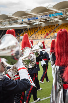 Details from a fanfare music, show and marching band. Playing musicians with wind and percussion instruments in uniforms.