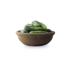 Fresh сucumbers in wooden bowl isolated on white background. Cucumbers with copy space for text.