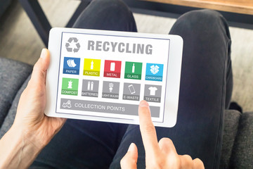 Person using tablet website for sorting recyclable waste material, recycling