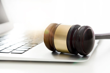 Wooden gavel on laptop keyboard.