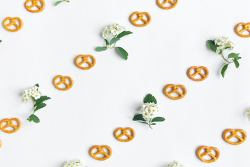 Cookies pretzels and flowers pattern on white background. Flat lay, top view