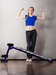 Woman behind sit ups bench