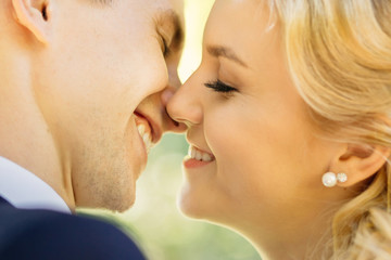 Closeup of beautiful happy couple kissing outdoors