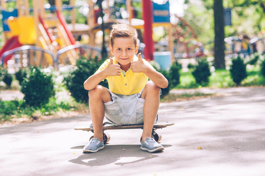 Little boy is riding a skateboard in the park