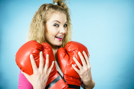 Funny girl with red gloves playing sports boxing