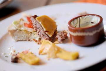 Messy food leftovers. Burger leftover on the plate after party