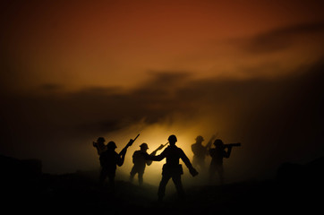 Fototapeta na wymiar War Concept. Military silhouettes fighting scene on war fog sky background, World War Soldiers Silhouettes Below Cloudy Skyline At night. Attack scene. Armored vehicles. Tanks battle