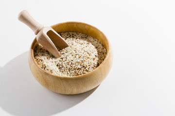 ISOLATED SESAME WITH WOODEN SPOON AND BOWL ON WHITE BACKGROUND