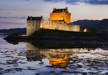 Eilean Donan Castle at Kyle reflecting itself into the water of Loch Duich and loch Alsh, during evening low tide.