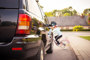 Fototapeta premium Accident. Girl on the bicycle crosses the road in front of a car